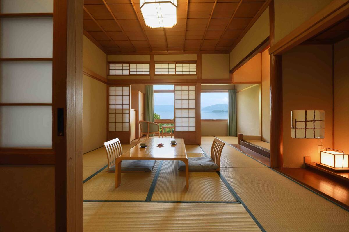 A traditional Japanese room with tatami flooring, a low wooden table, and sliding doors.