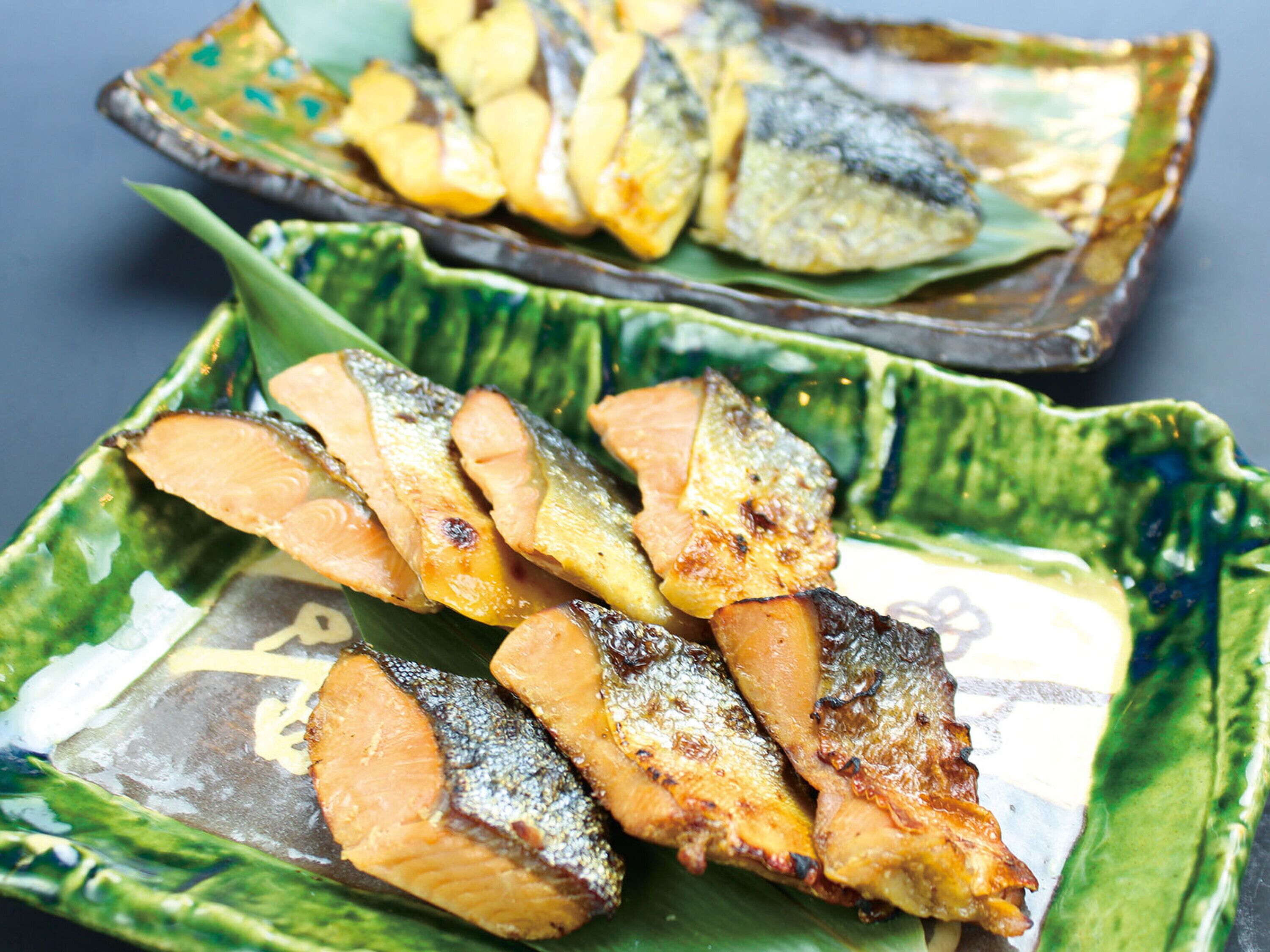 Grilled fish served on decorative plates.