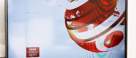 A television displaying the BBC World News logo, indicating a news broadcast.