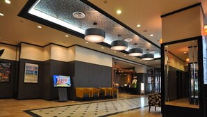 A hotel lobby with a reception desk, seating area, and a large mirror. - APA Hotel Obihiro Ekimae (Obihiro)