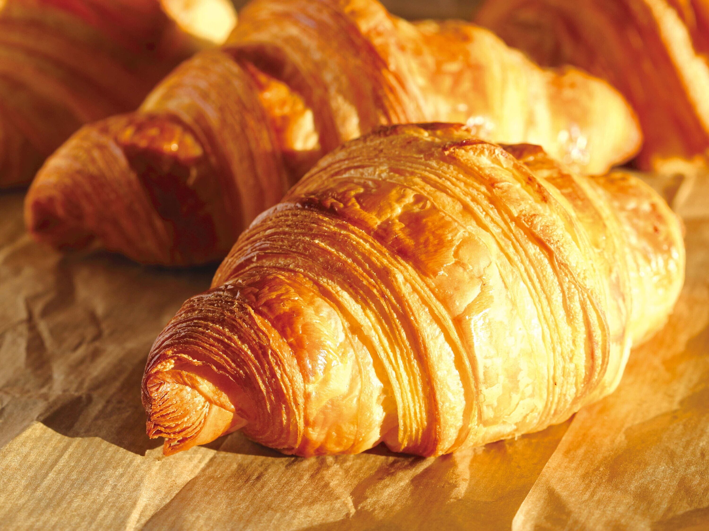 A close-up of croissants on parchment paper.