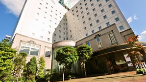 A multi-story hotel with a modern design, featuring a prominent entrance with a curved facade and a sign indicating a spa facility. - APA Hotel Obihiro Ekimae (Obihiro)