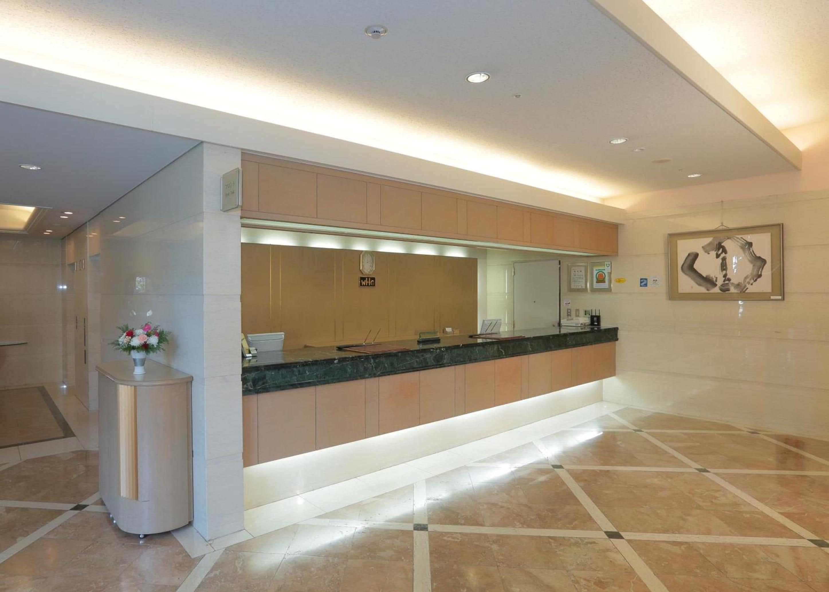 A modern reception area with a marble floor, a reception desk, and a framed artwork on the wall.