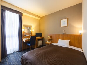 A hotel room with a bed, desk, chair, and a small TV. - Urawa Washington Hotel (Saitama)