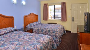 A hotel room with two beds, a television, and a window with curtains. - Rodeway Inn (Sacramento)