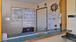 A reception area with a calendar, a ship's wheel decoration, and a no smoking sign. - Rodeway Inn (Sacramento)