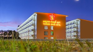 A hotel with a prominent sign in a foreign language, multiple floors, and a crescent moon in the sky. - Thansur Sokha Hotel (Kampot)