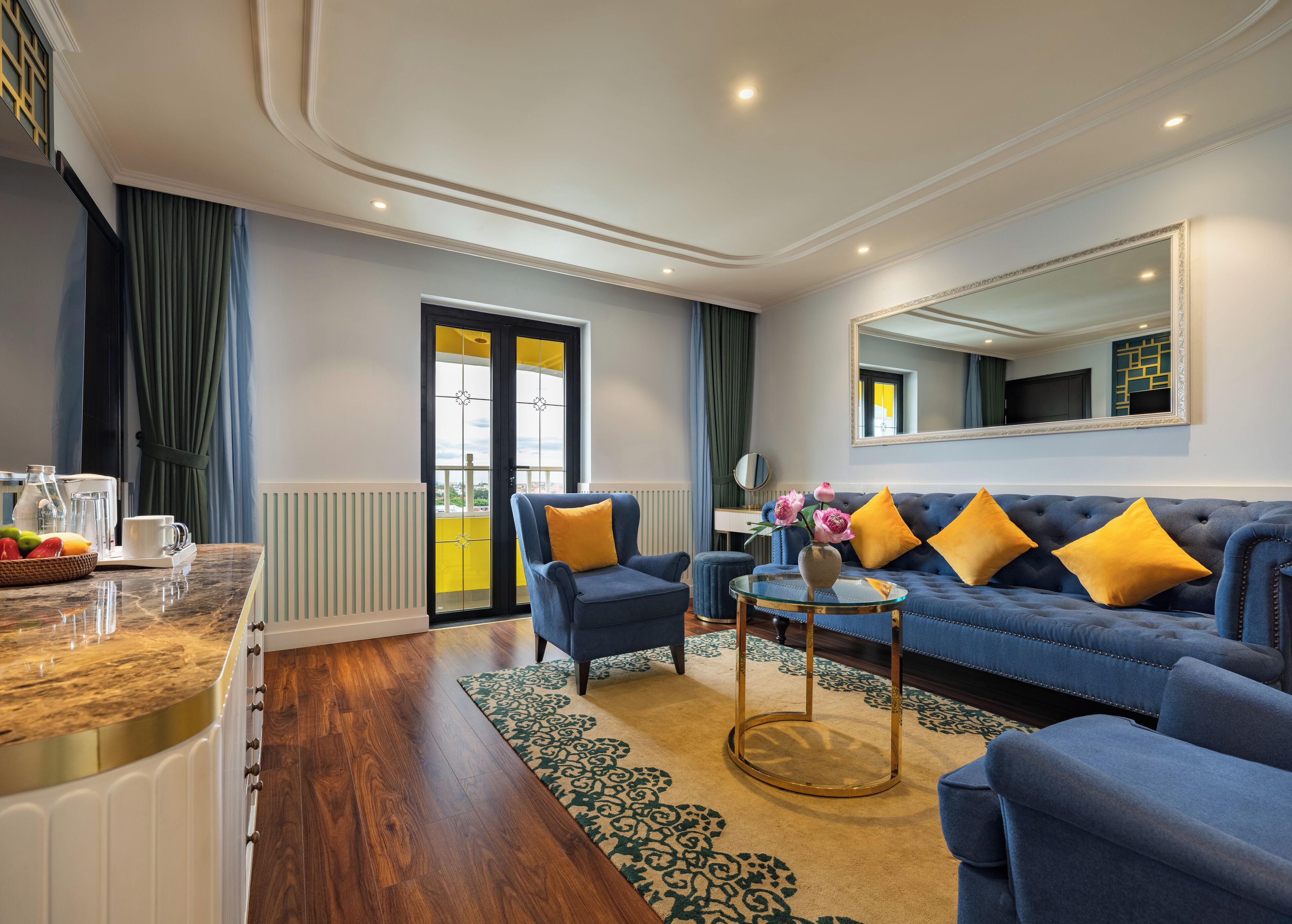 A modern living room with a blue sofa, yellow cushions, a coffee table, and a large mirror.