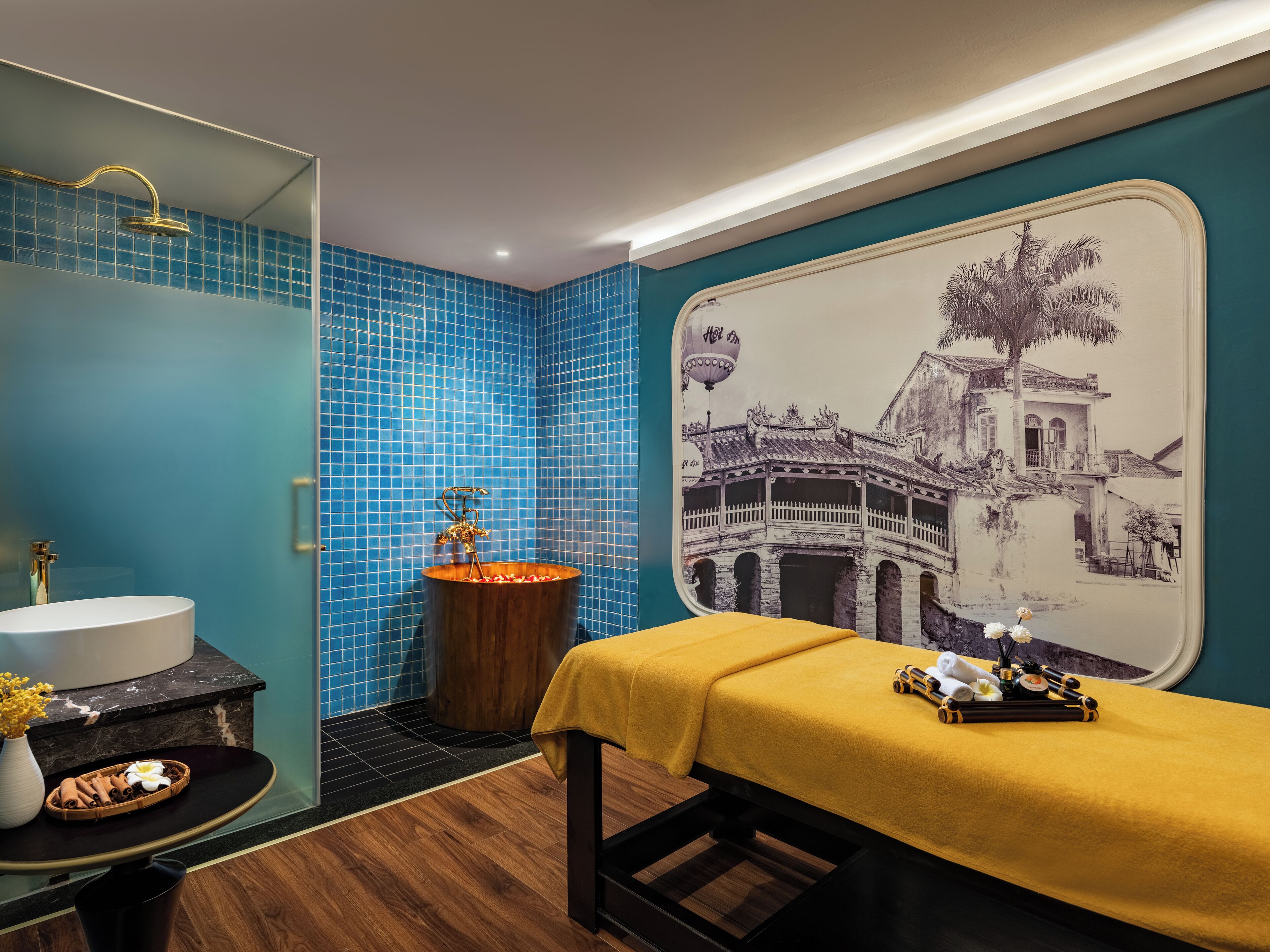 Ein Badezimmer mit Waschbecken, Badewanne und einer Massageliege.