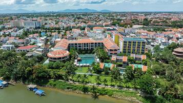 A hotel with multiple buildings, a swimming pool, and a river.