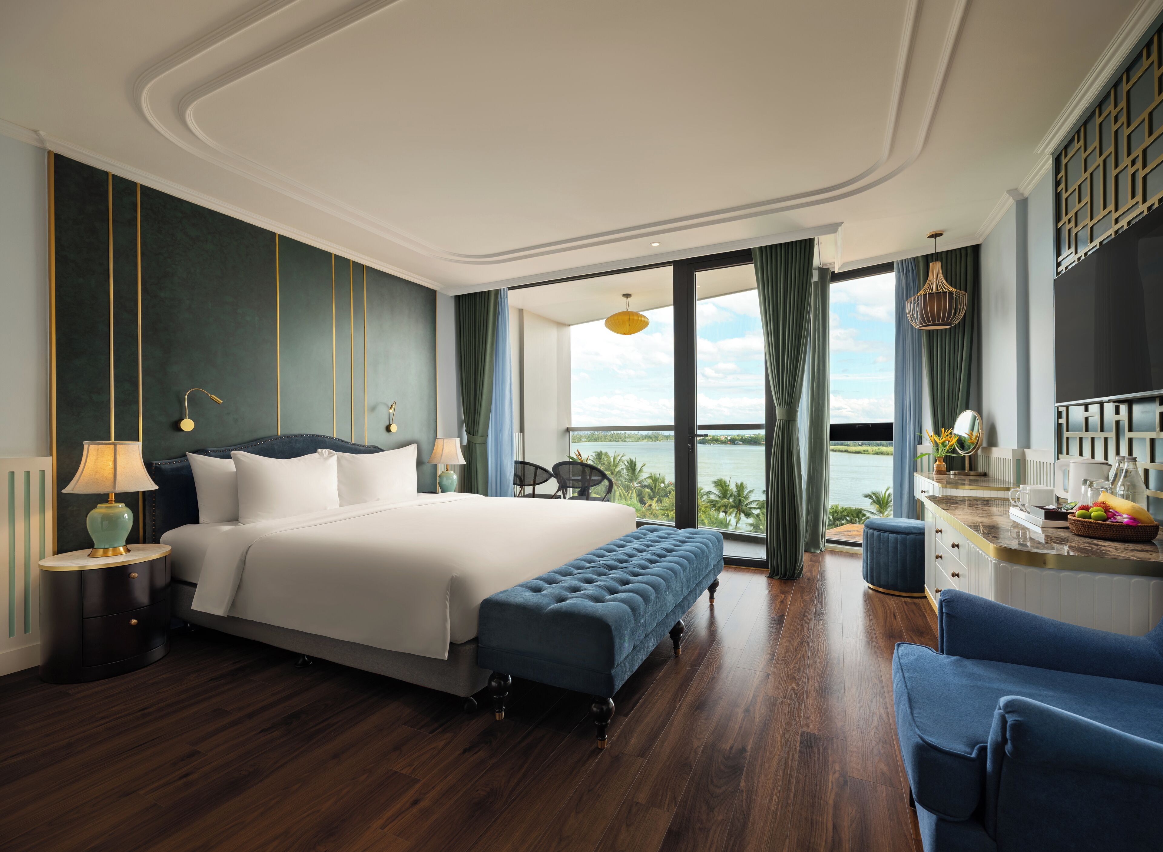 Ein modernes Hotelzimmer mit einem großen Bett, einer Sitzecke und Meerblick.