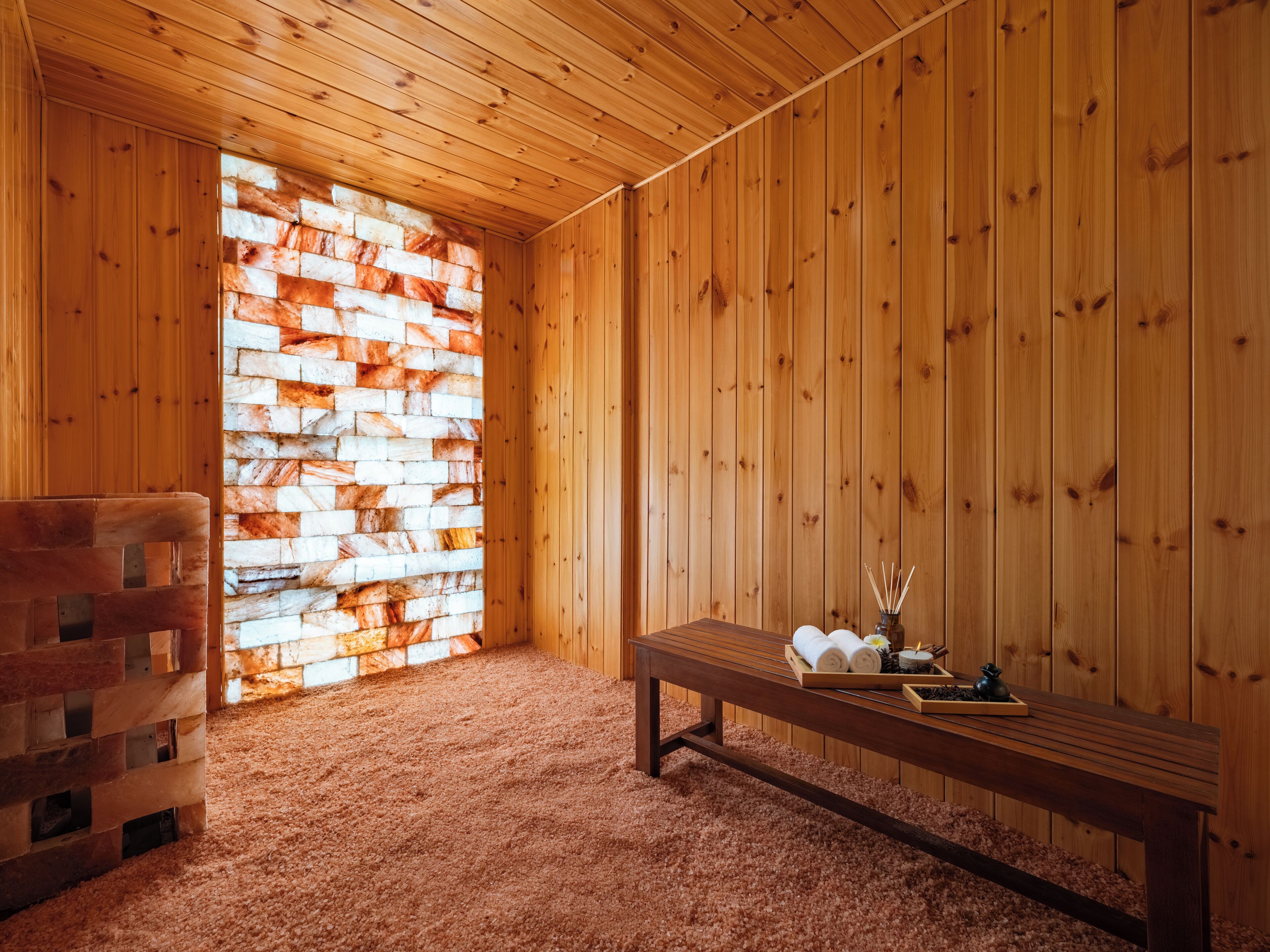 Una habitación de madera con un banco, una pared de ladrillo y suelo de madera.