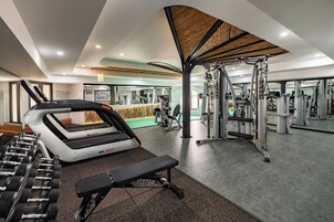 A modern gym with treadmills, dumbbells, and weight machines.