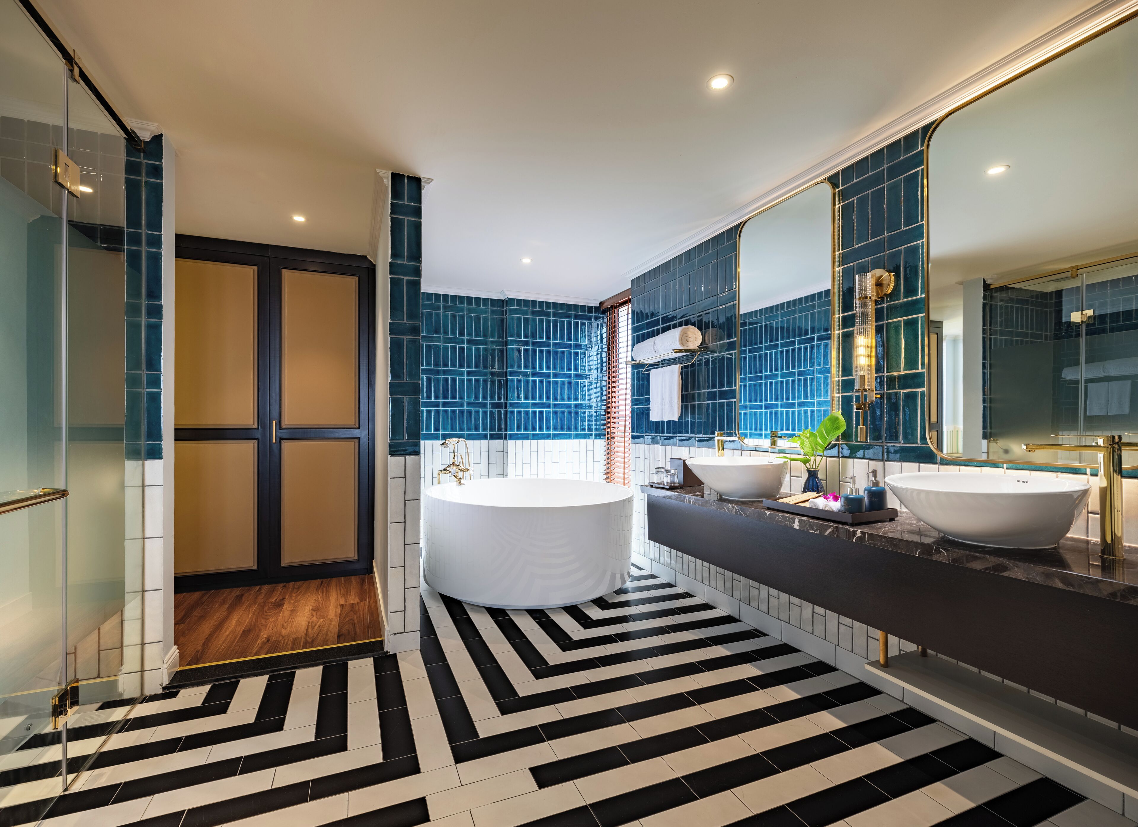 Een moderne badkamer met een vrijstaand bad, twee wasbakken en een grote spiegel.