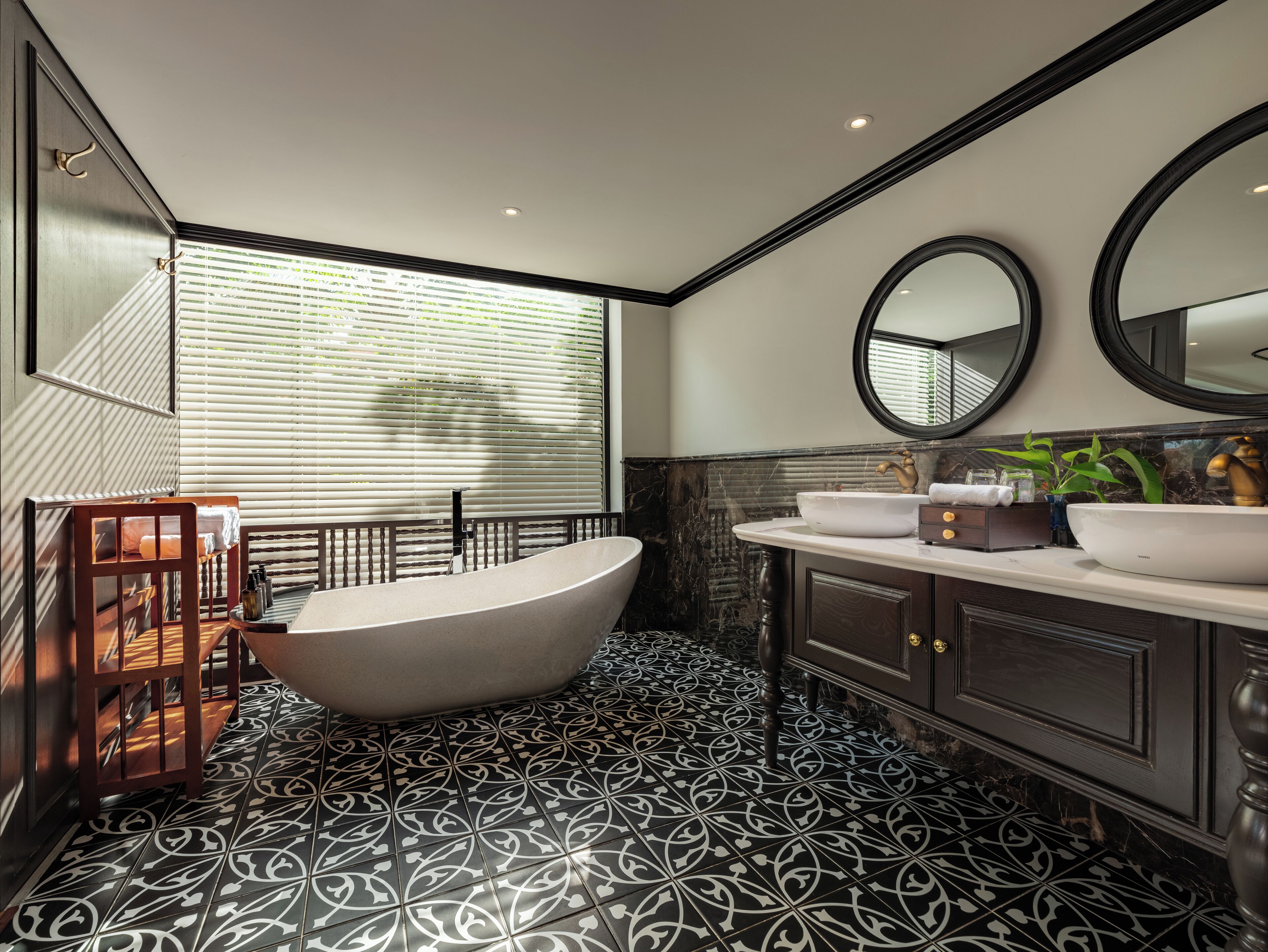 Une salle de bain moderne avec une baignoire sur pieds, un grand miroir et un meuble-lavabo.