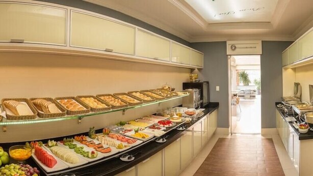 A buffet with various food items and a glass display case. - Hotel KK (Itu)
