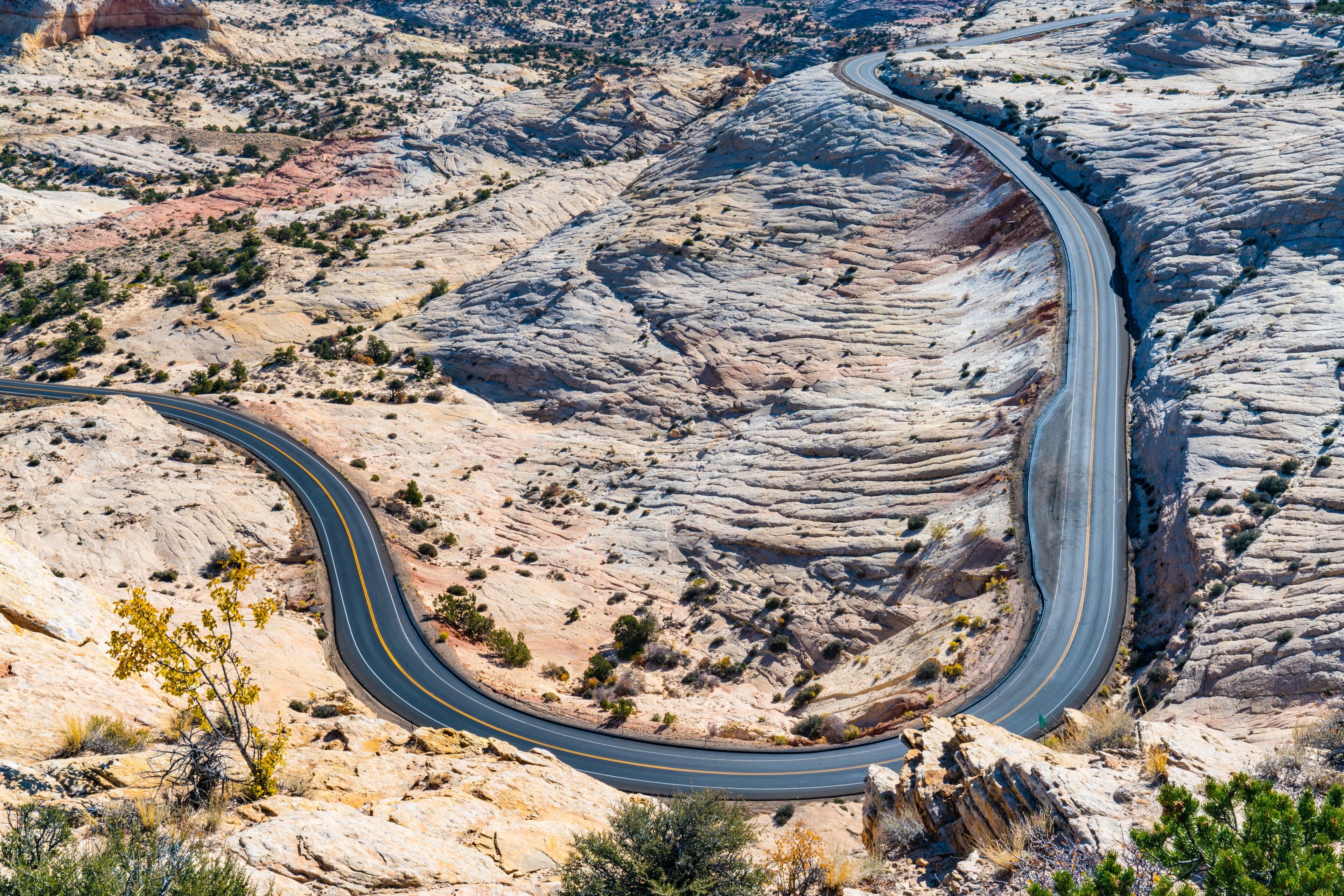 Un chemin sinueux traverse un paysage rocheux où la végétation est rare.