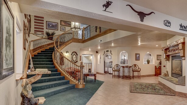 A spacious foyer with a grand staircase, a fireplace, and a dining area. - The Snuggle Inn (Loa)
