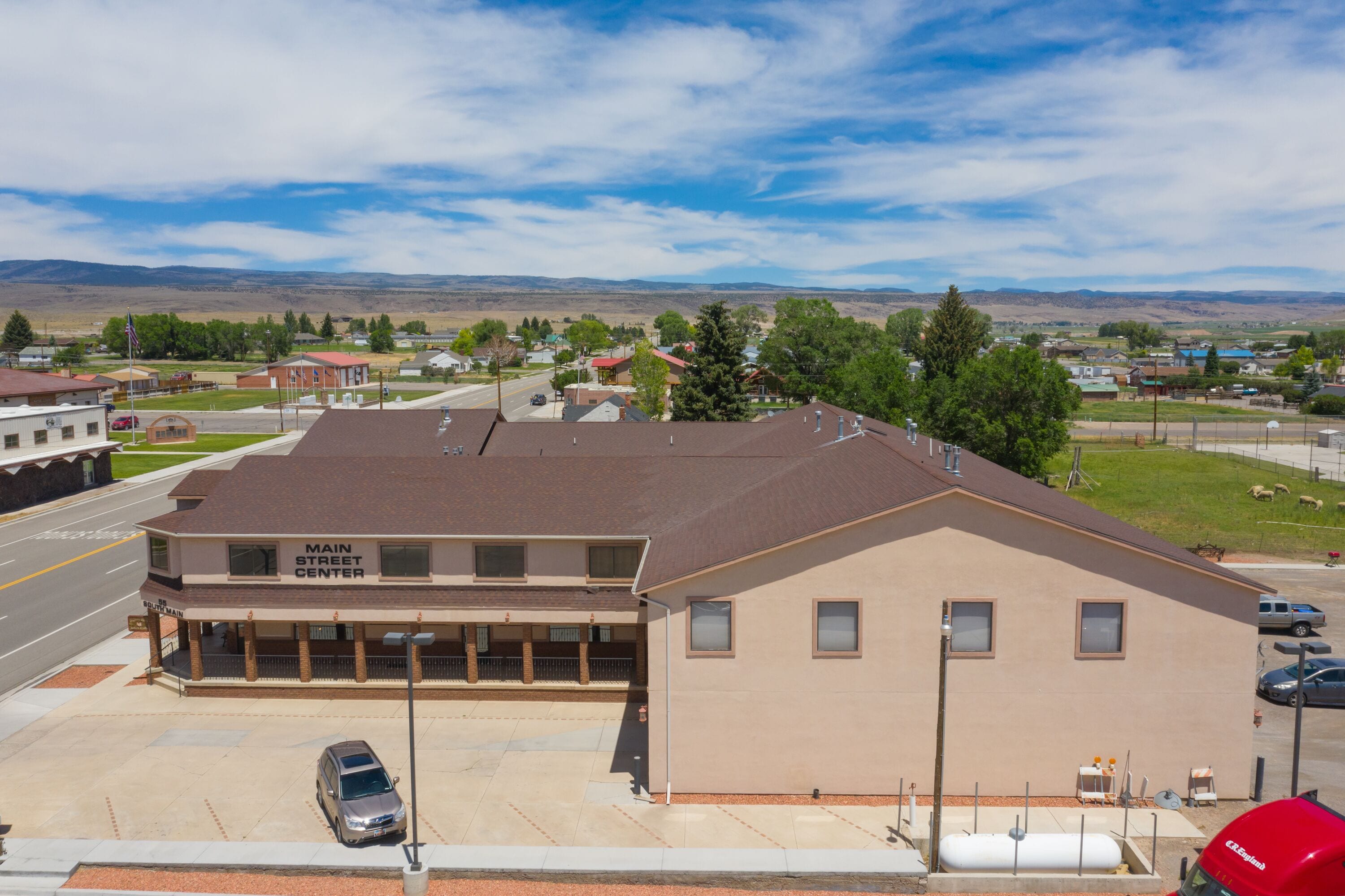 A building labeled "Main Street Center" with a parking lot, a road, and a mountainous landscape in the background.