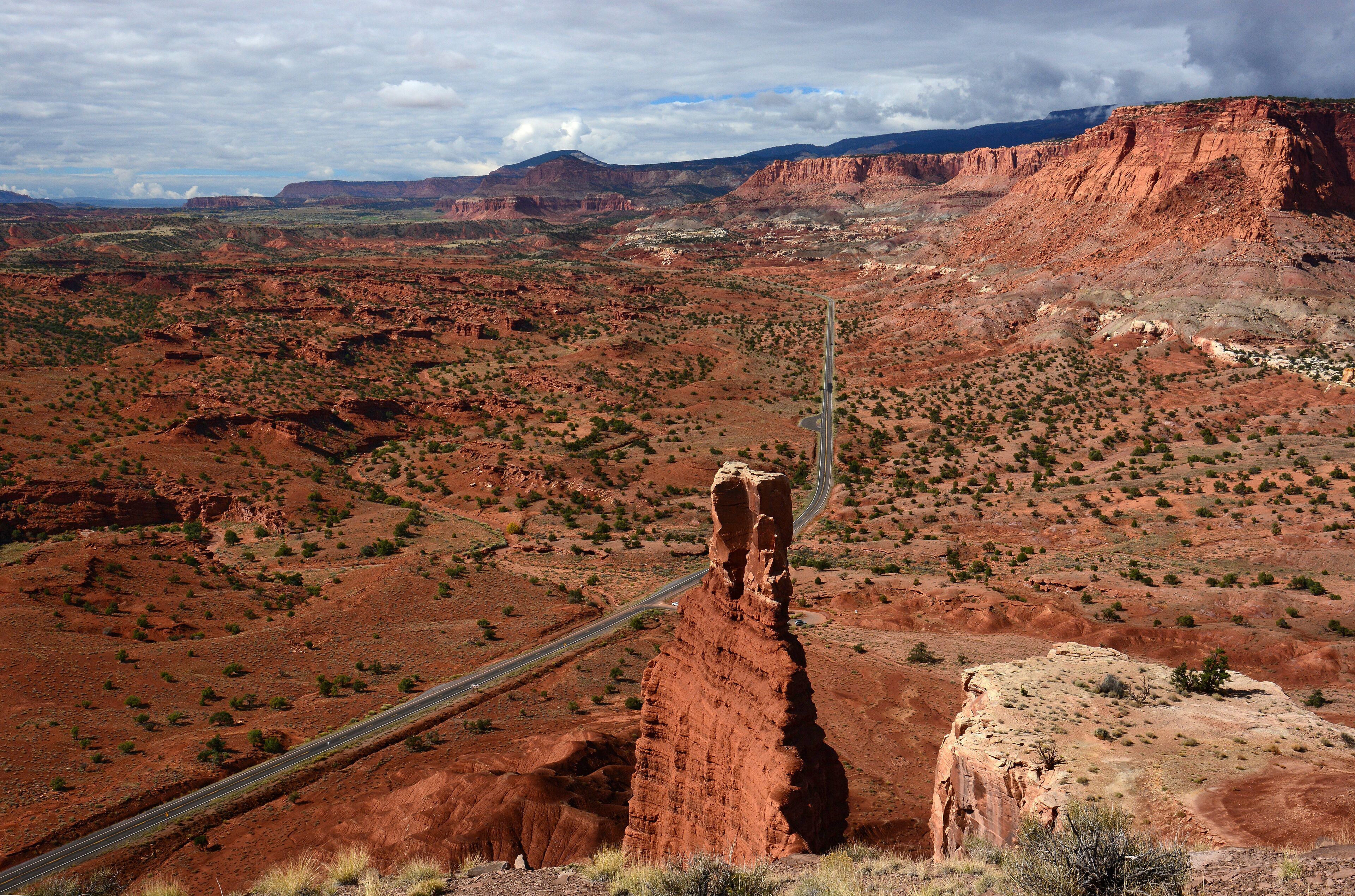Un paysage accidenté, avec une route sinueuse et une formation rocheuse imposante.