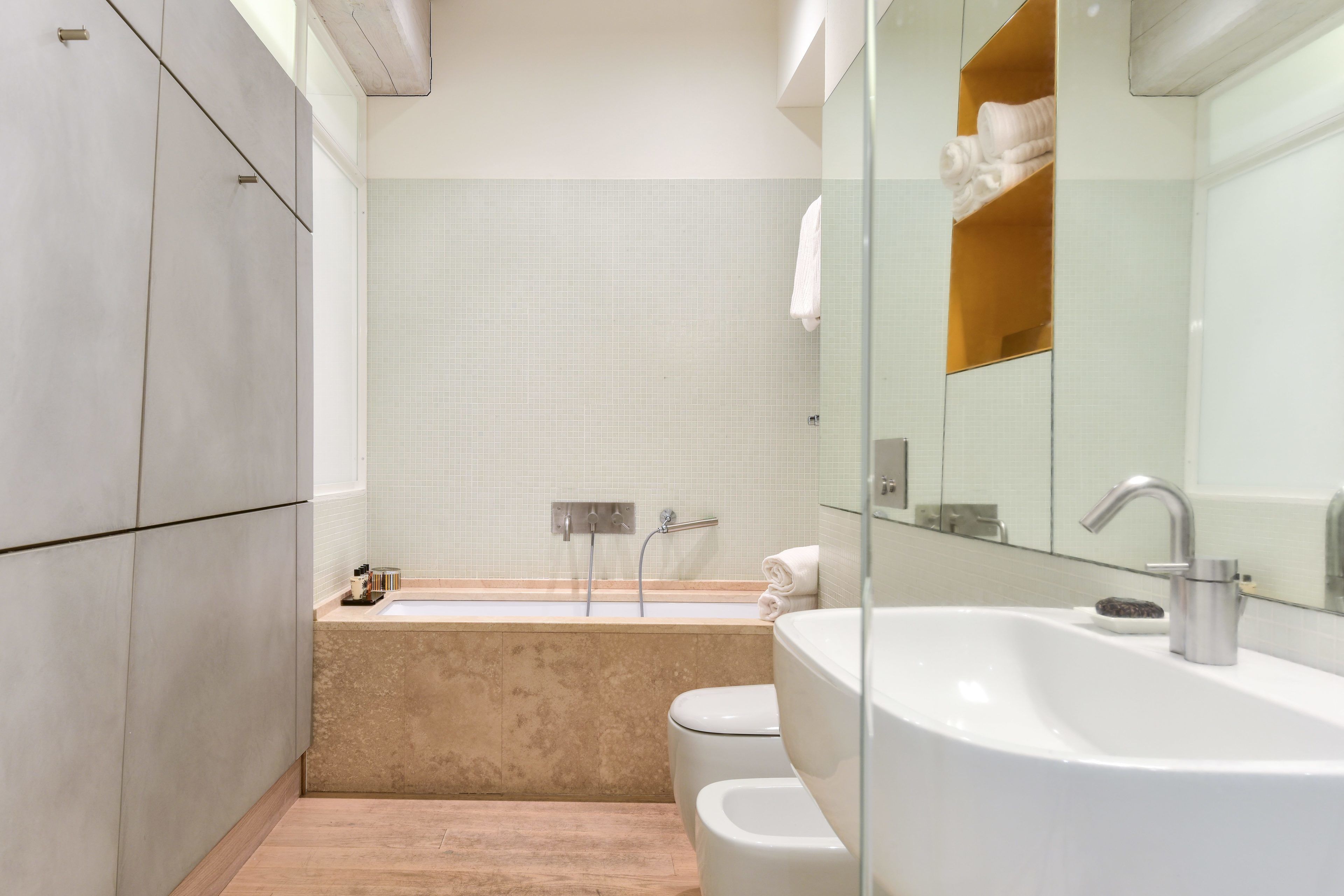 Een moderne badkamer met een bad, een wastafel en een toilet.