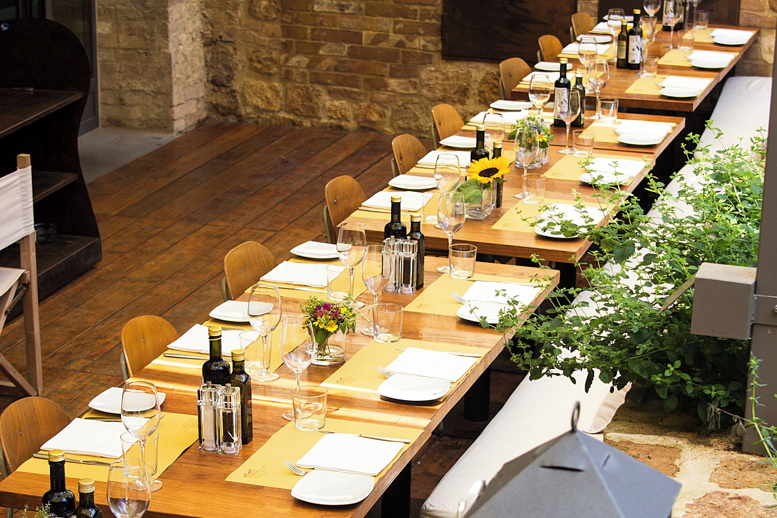 A long dining table set with chairs, wine glasses, and bottles, suggesting a formal dining area.