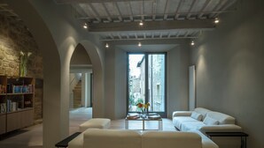 Uma sala de estar moderna com um sofá branco, uma mesa de centro e uma estante.