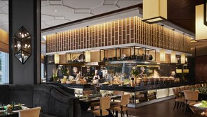 Ein modernes Restaurant mit Barbereich, Sitzmöglichkeiten und einer im Hintergrund sichtbaren Küche.