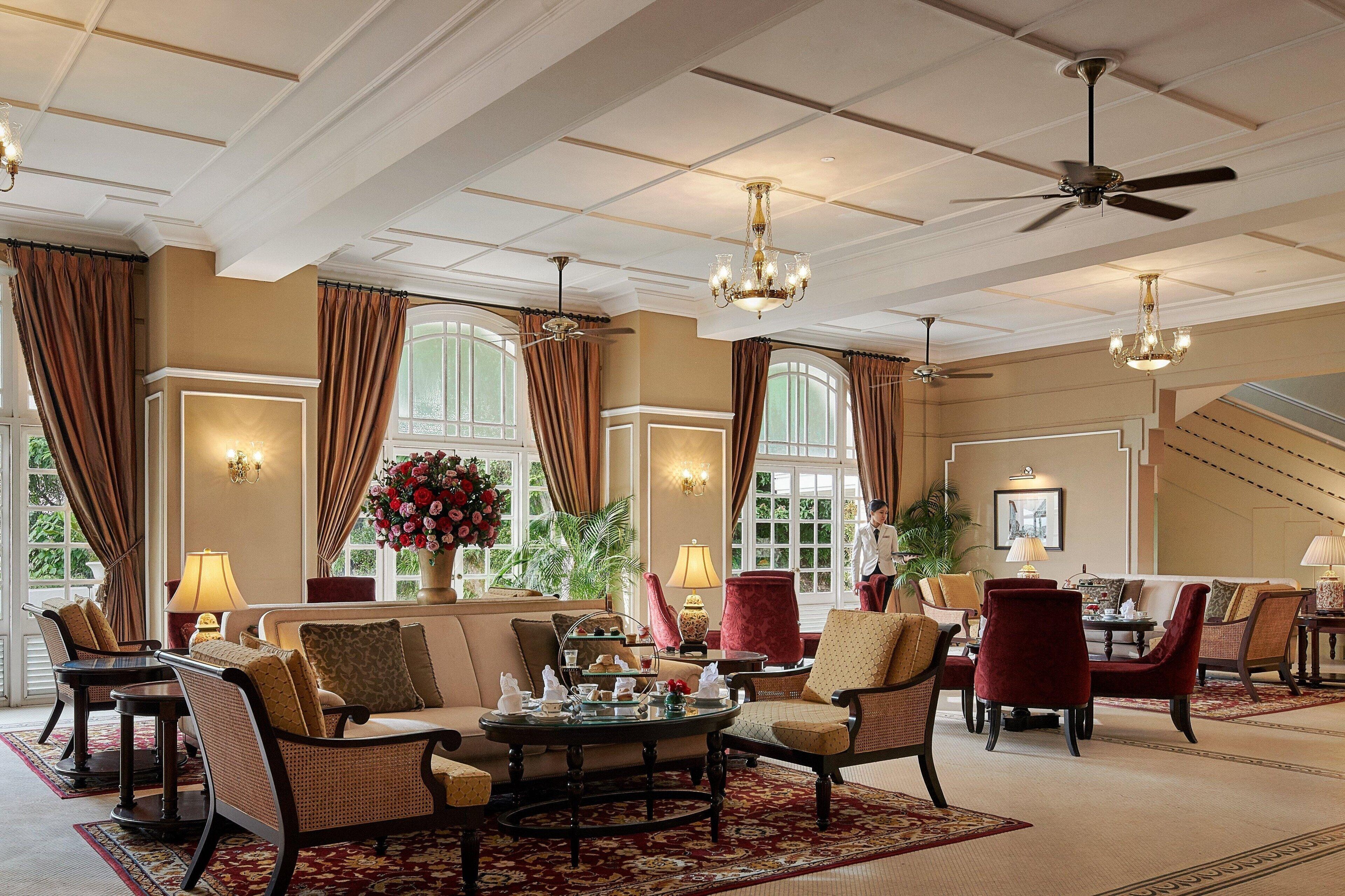 A spacious lobby with a high ceiling, chandeliers, and comfortable seating areas.