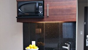 A compact kitchen with a microwave, sink, and a small refrigerator. - Holiday Inn Express Pembroke by IHG (Pembroke)
