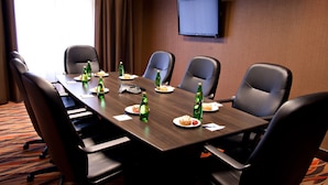 A conference room with a long table, six chairs, and a TV on the wall. - Holiday Inn Express Pembroke by IHG (Pembroke)