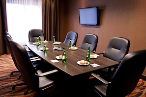 A conference room with a long table, six chairs, and a TV on the wall. - Holiday Inn Express Pembroke by IHG (Pembroke)