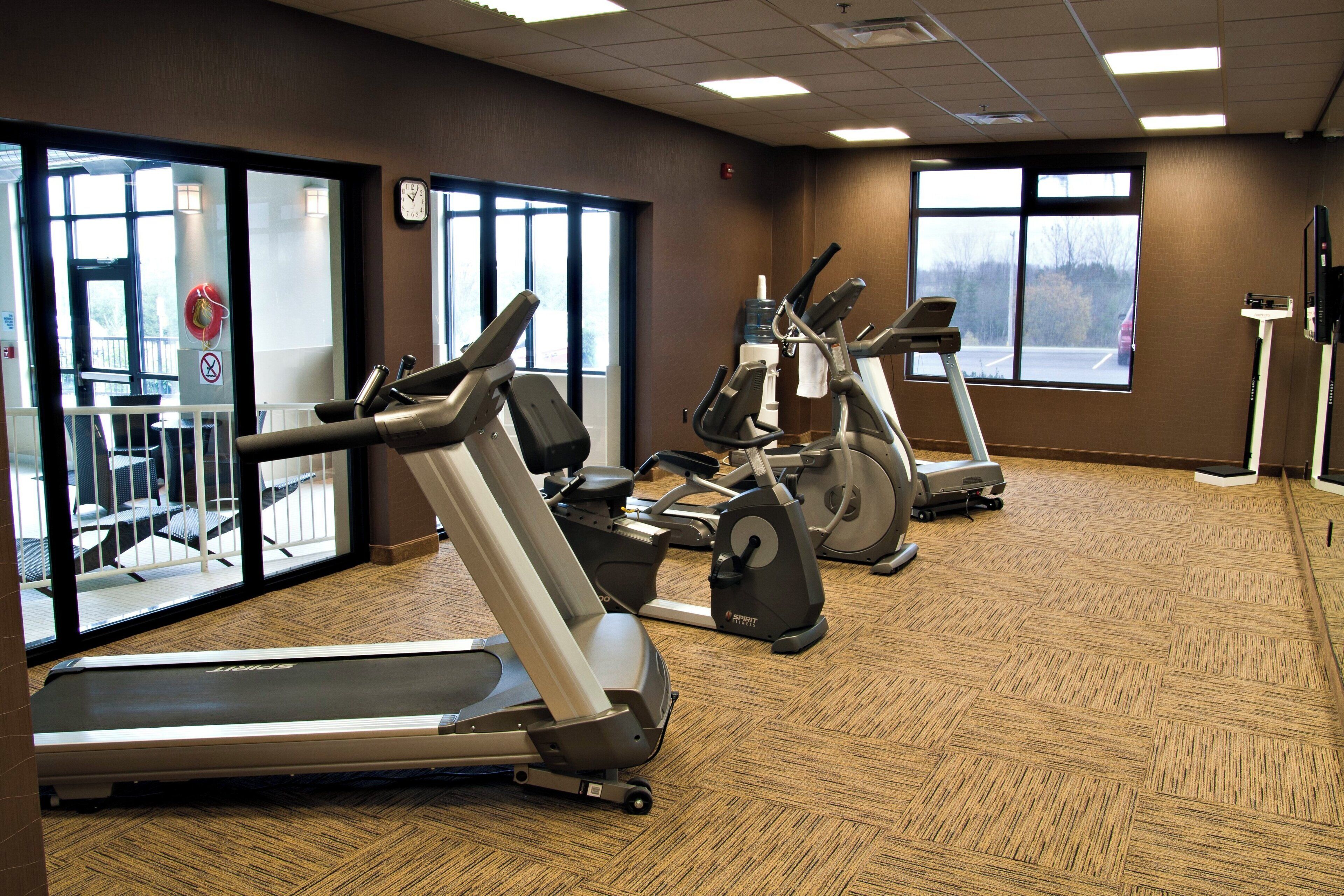 A gym with treadmills, stationary bikes, and a water cooler.