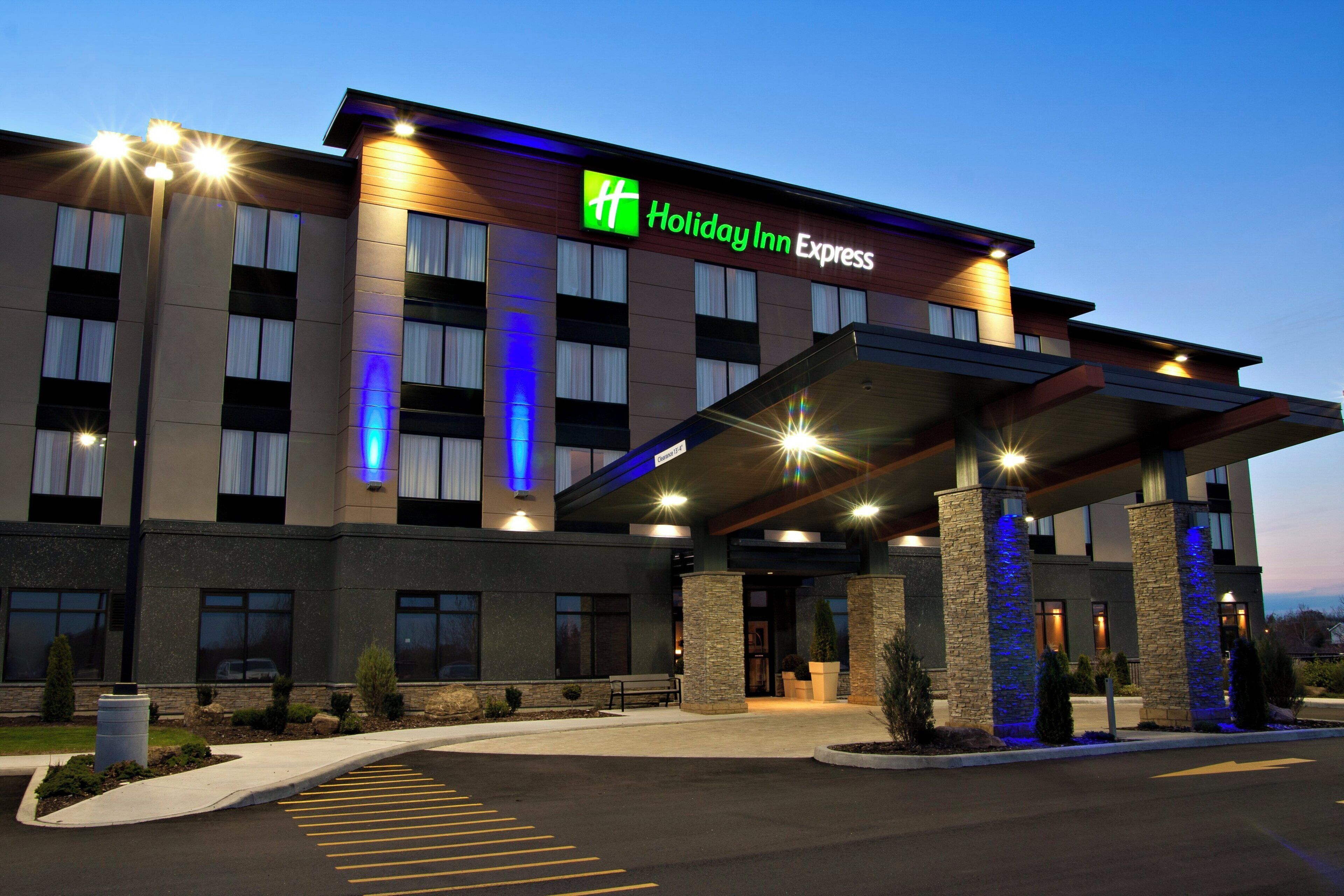 A Holiday Inn Express hotel with a modern facade, large windows, and a covered entrance area.