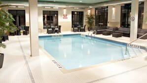 An indoor swimming pool with a shallow area marked, surrounded by seating and a sign indicating shallow water. - Holiday Inn Express Pembroke by IHG (Pembroke)