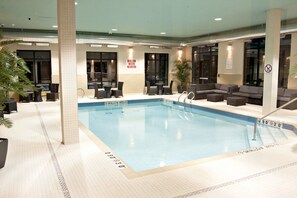 An indoor swimming pool with a shallow area marked, surrounded by seating and a sign indicating shallow water. - Holiday Inn Express Pembroke by IHG (Pembroke)