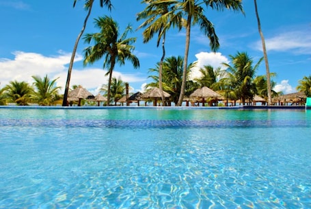 Una piscina al aire libre, camas de piscina gratis, sombrillas