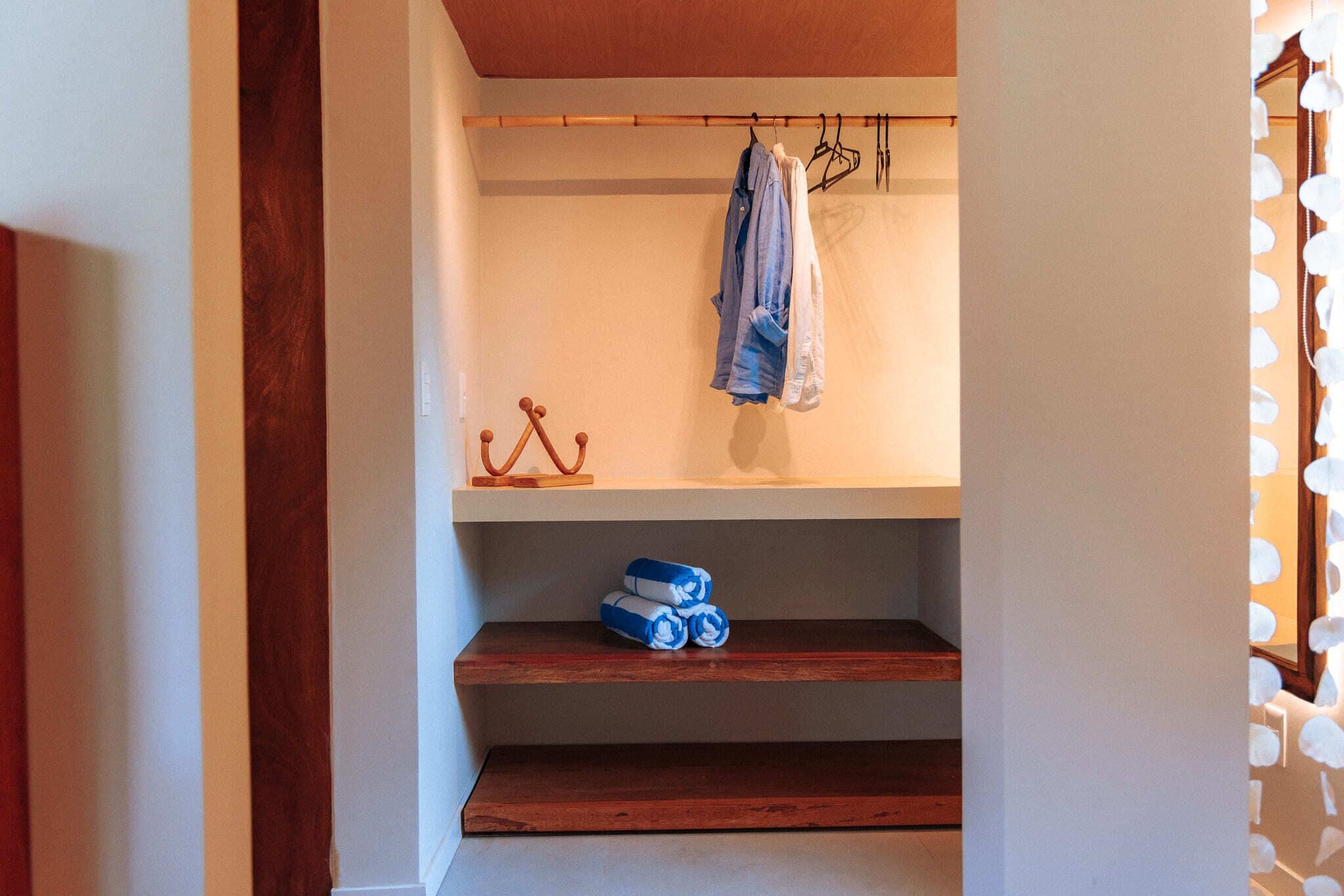 Un armadio con mensole in legno, un appendiabiti e un oggetto decorativo.
