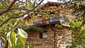 Un edificio de piedra con balcón y ventana.