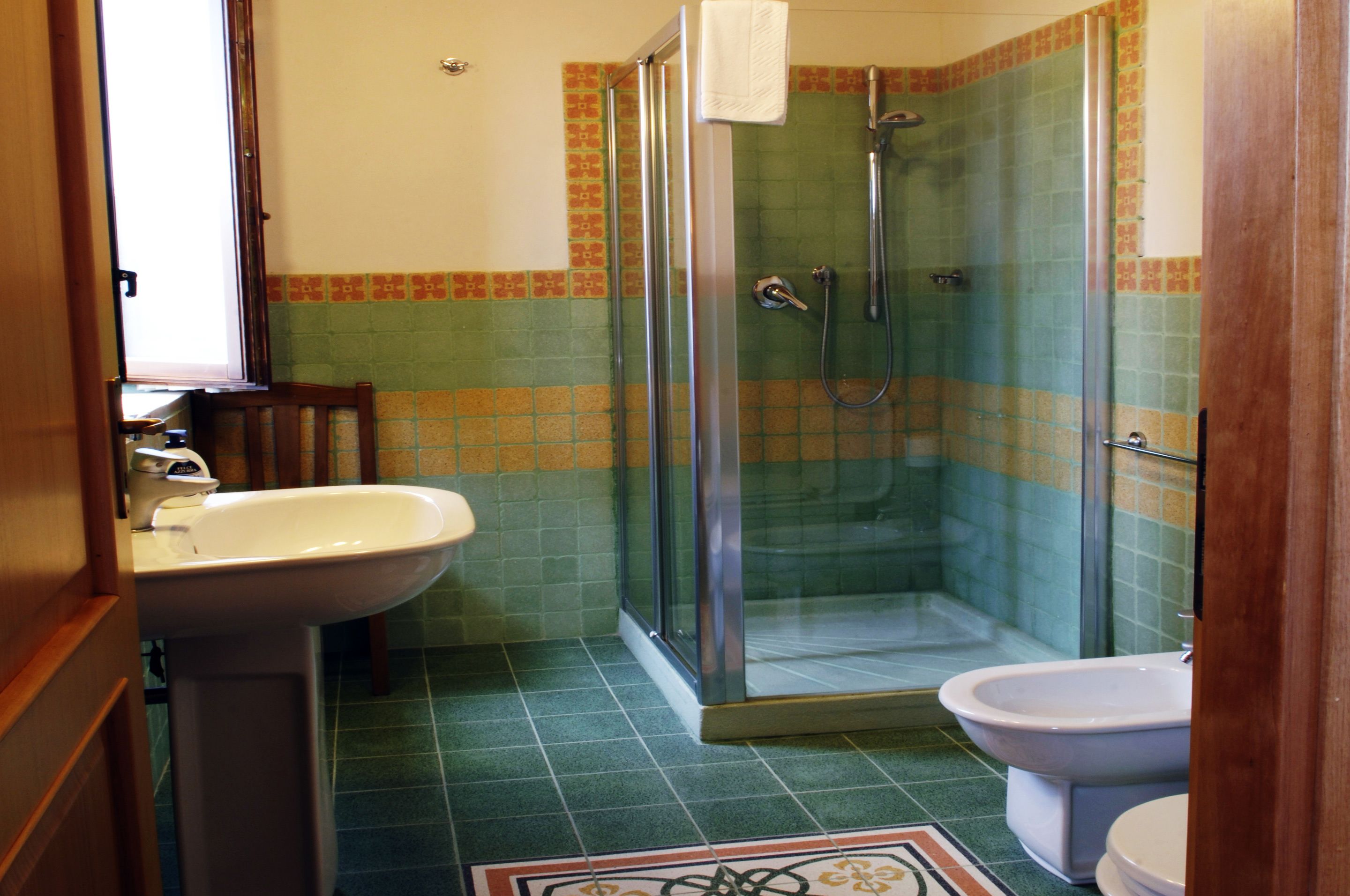 A bathroom with a glass-enclosed shower, a sink, and a toilet.