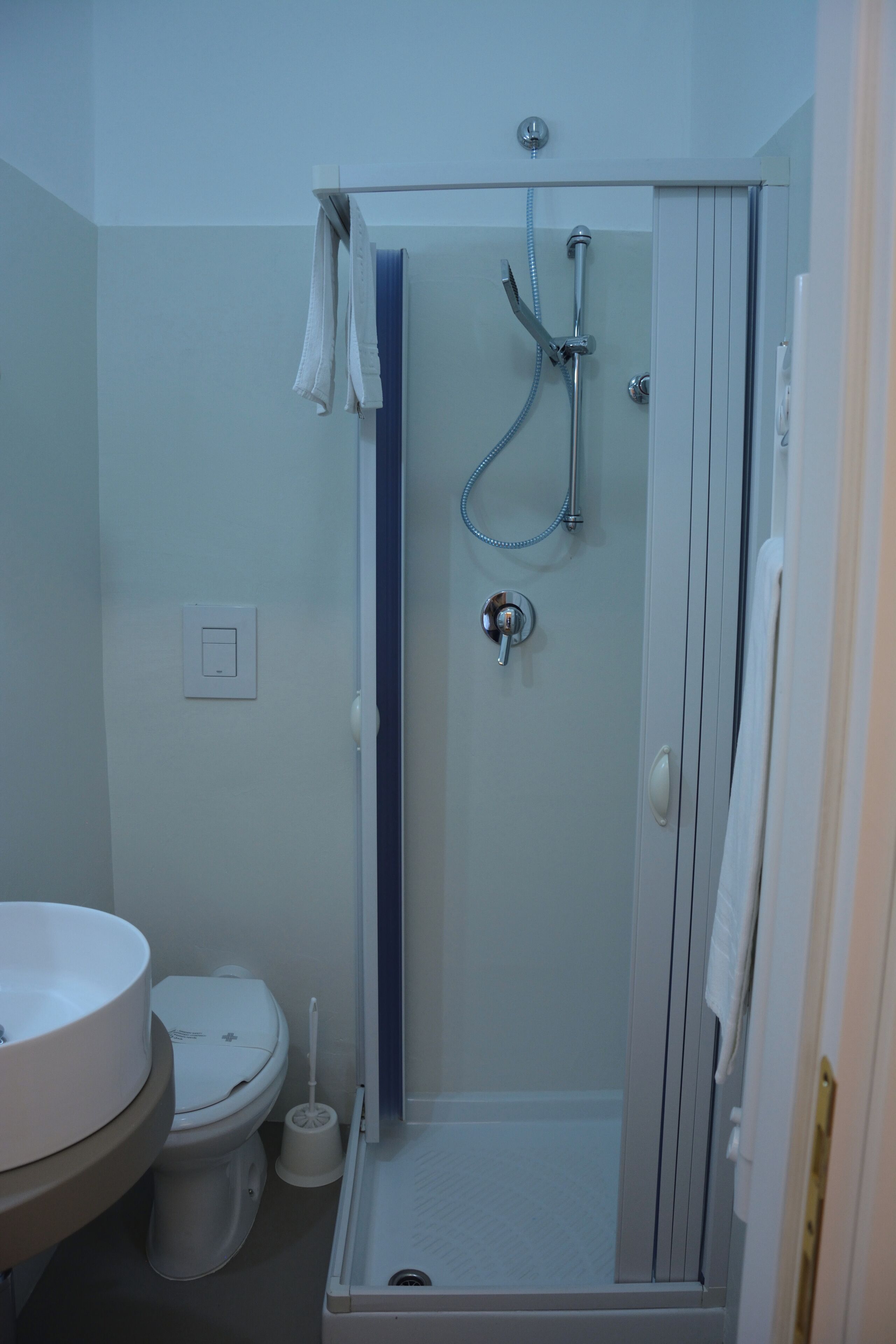 Une salle de bain avec douche, toilettes et lavabo.