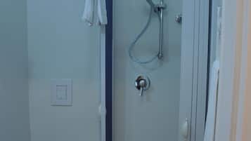 Une salle de bain avec douche, toilettes et lavabo.