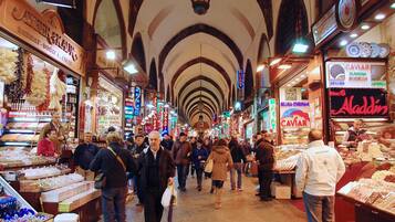 A bustling indoor market with various stalls selling goods.