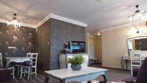 Ein modernes Wohnzimmer mit Fernseher, Sitzecke und Dekorationselementen.