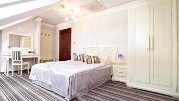 A bedroom with a bed, a desk, a chair, a wardrobe, and a striped floor.