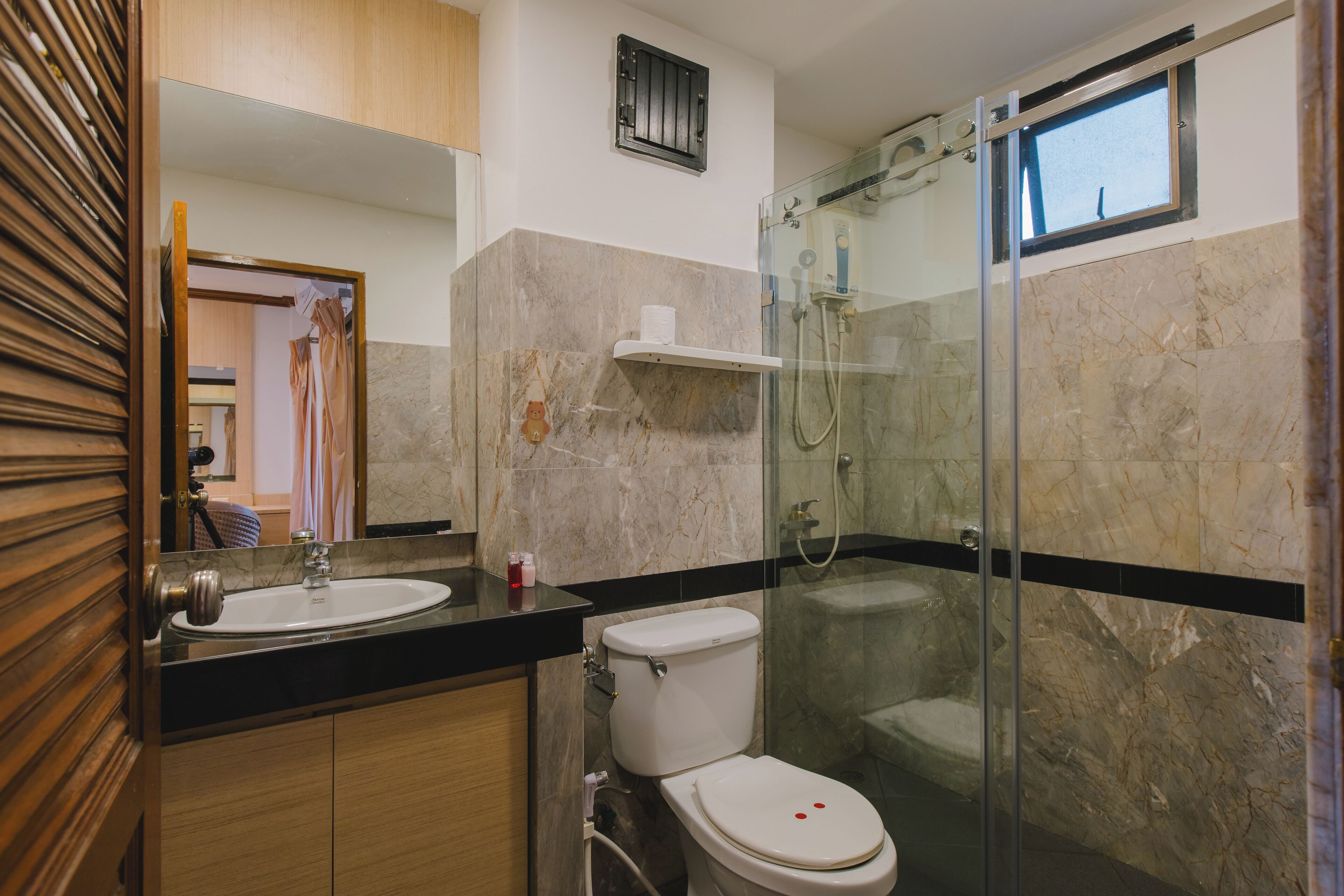 Ein modernes Badezimmer mit Marmorwaschbecken, Toilette und einer Duschkabine.