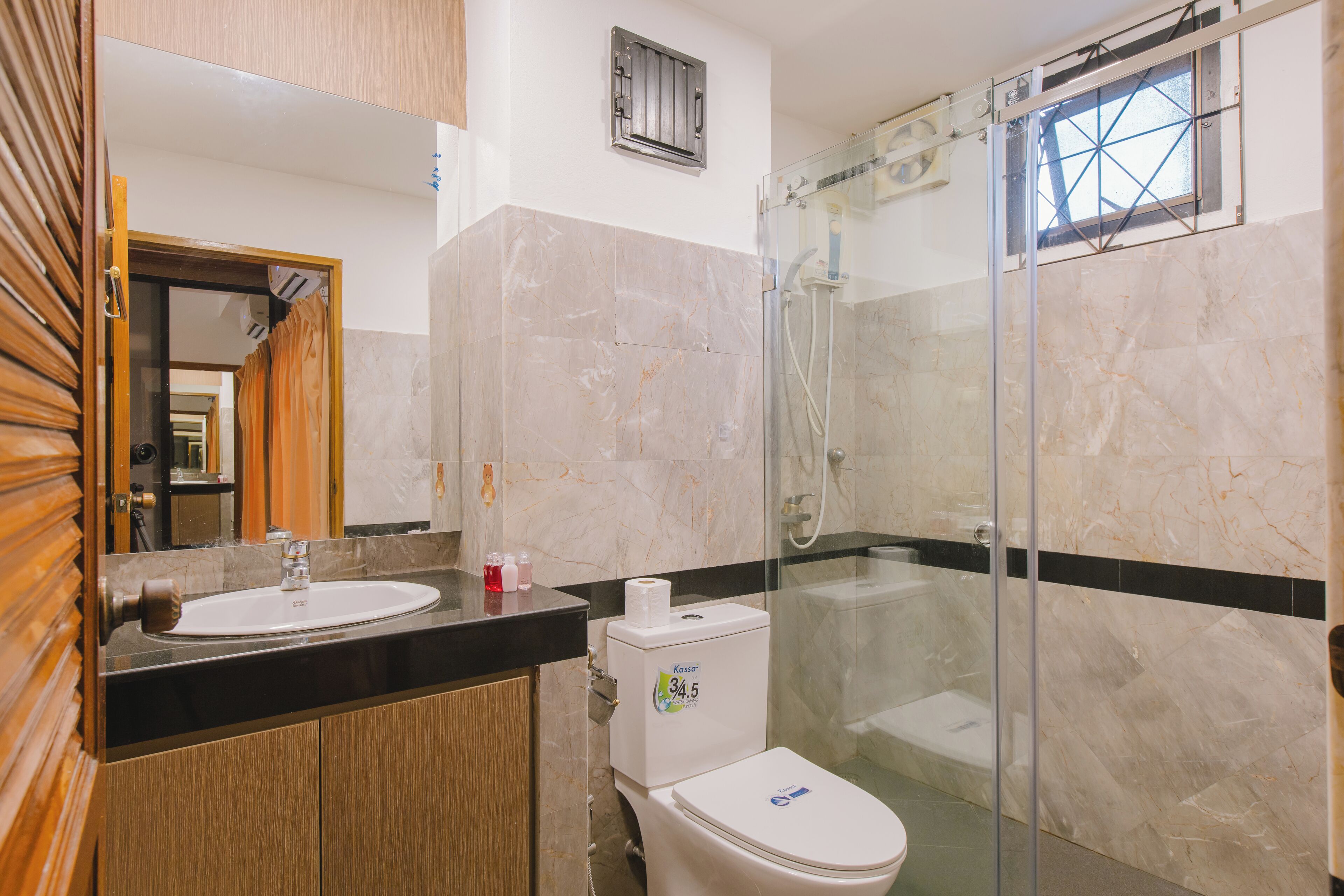 A bathroom with a sink, toilet, and glass shower enclosure.