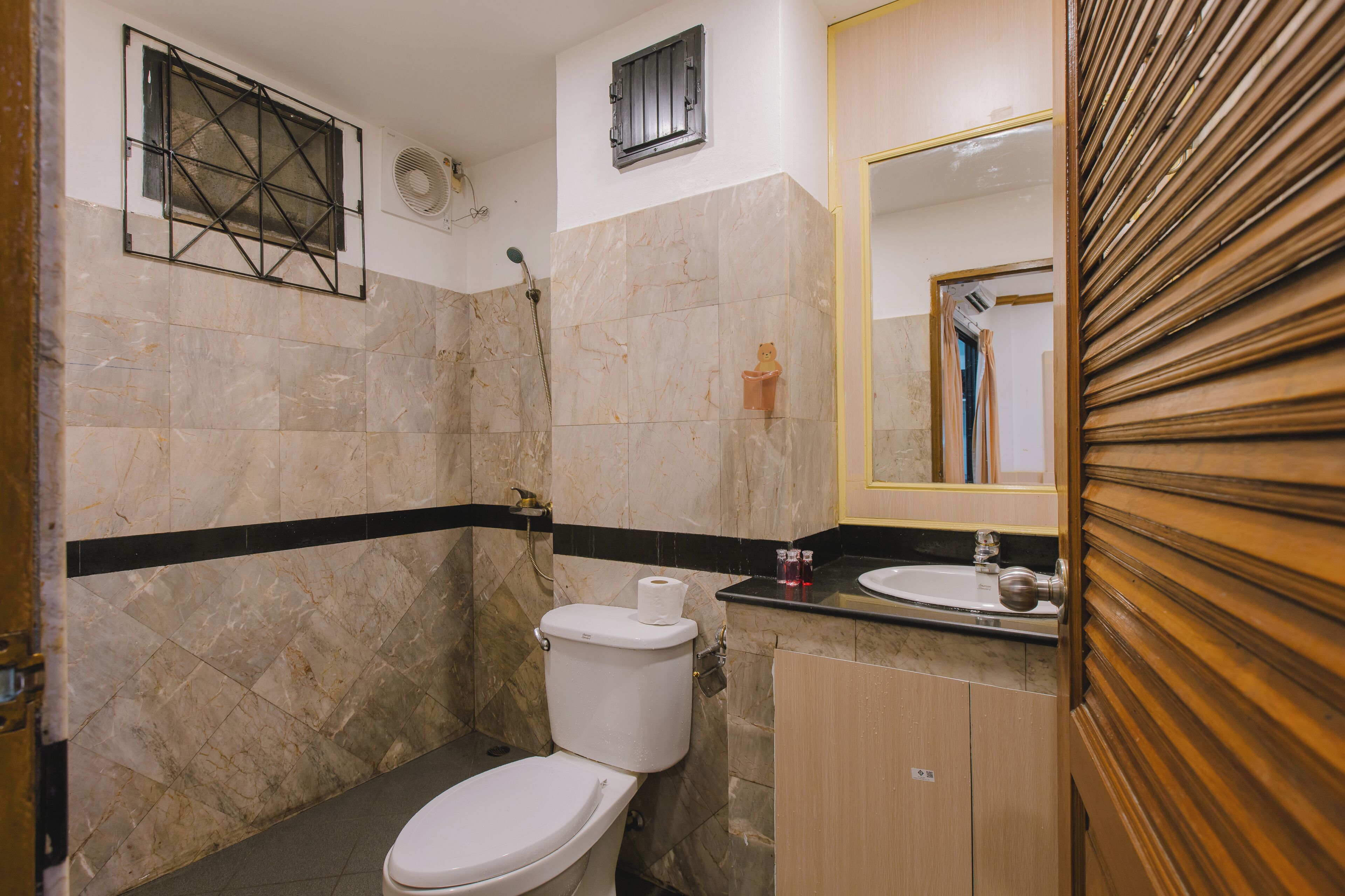 Een badkamer met toilet, wastafel en douche.