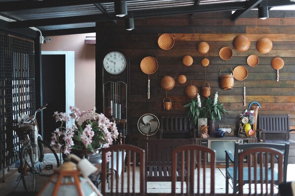 Comedor con paredes de madera, un reloj y varias cestas tejidas.