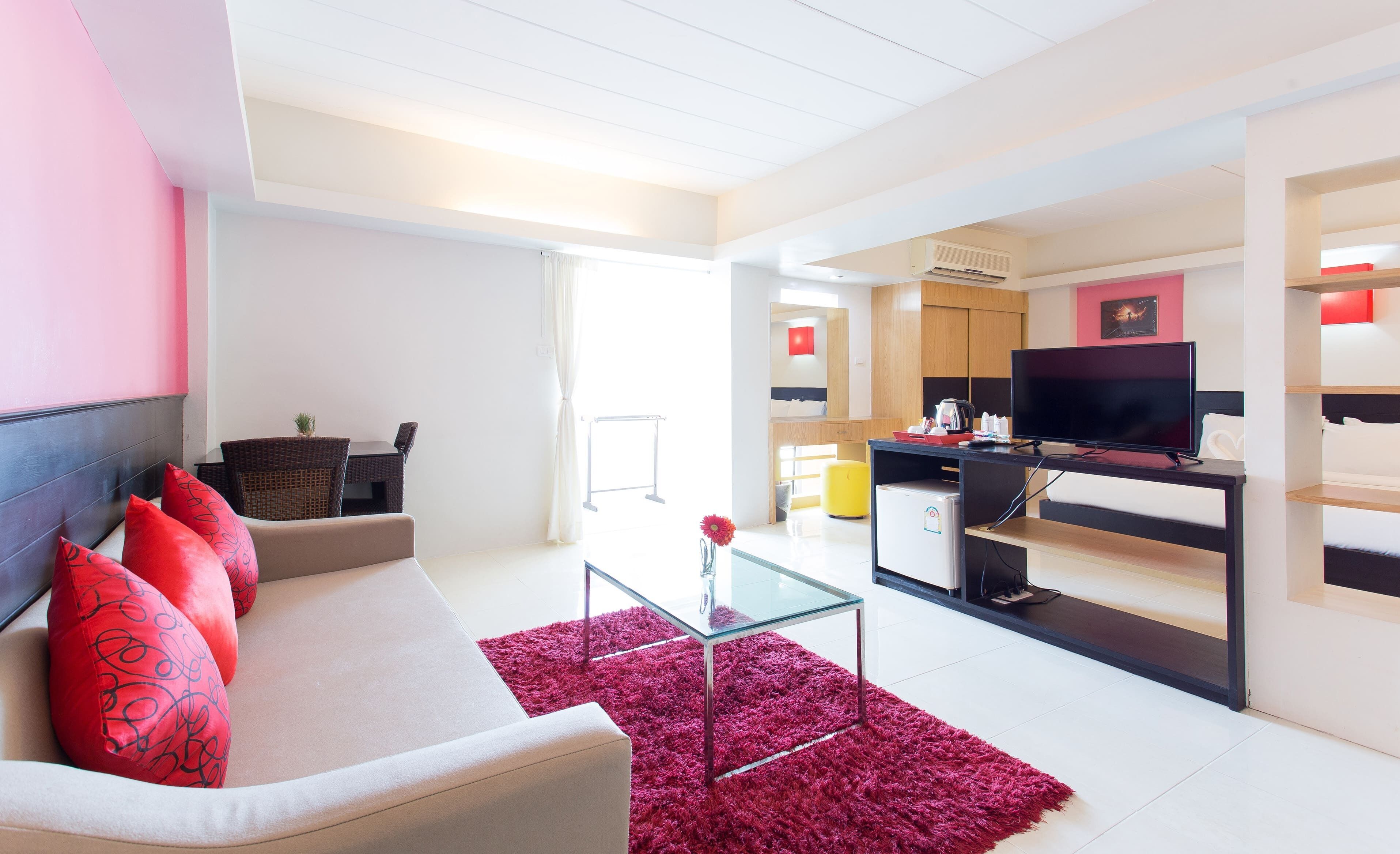 Una sala de estar moderna con un sofá, una mesa de centro y un televisor sobre un mueble.